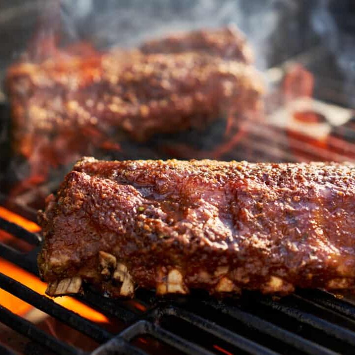 bbq ribs grilling over flaming grill
