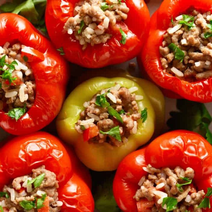 Close up of stuffed peppers with minced meat, rice, onion. Top view, flat lay
